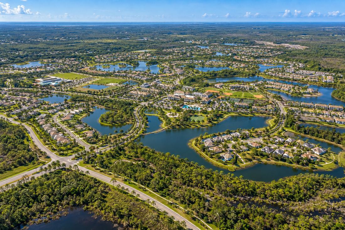Illustrative aerial concept of a Southwest Florida village with neighborhoods arranged around lakes and green corridors
